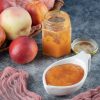apples in a wooden basket and applesauce in a confiture and a sauce cup