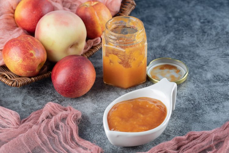 apples in a wooden basket and applesauce in a confiture and a sauce cup